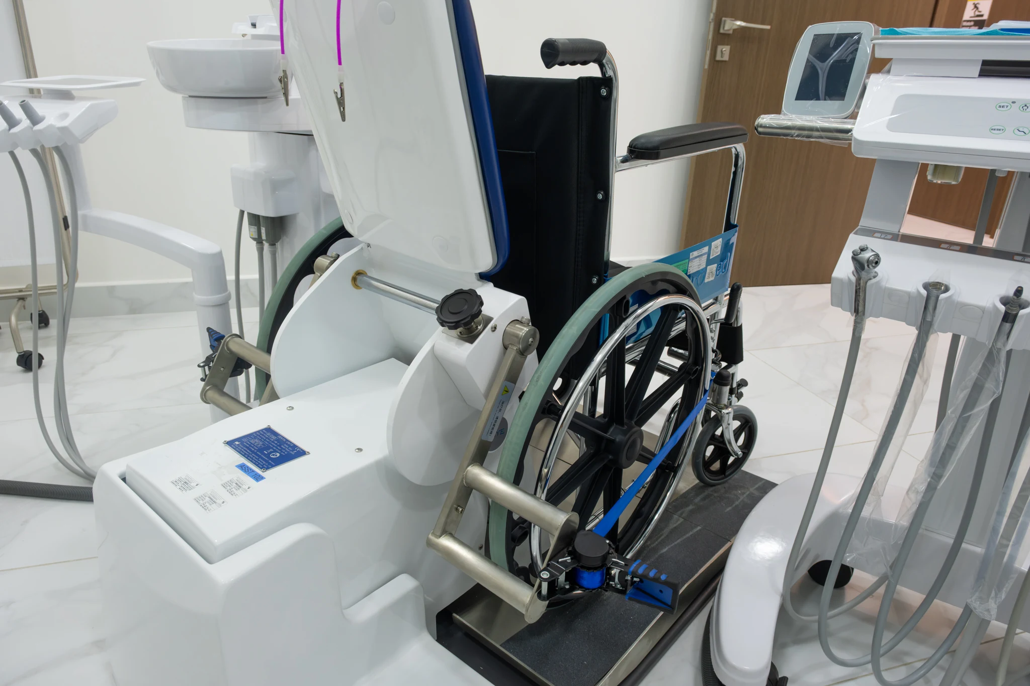 Close detail of the integrated accessible dental equipment beside the wheelchair at Silwadi Al Raha